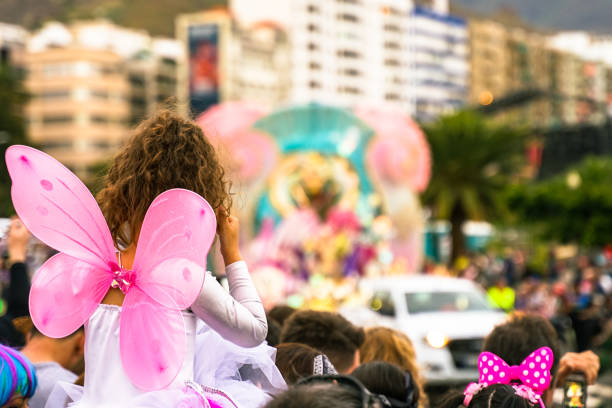 Bambina vestita da angelo a una sfilata di Carnevale